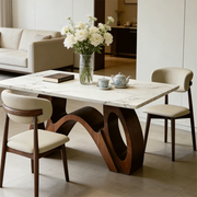 Modern sintered stone dining table with sculptural walnut wood base in minimalist dining room setting
