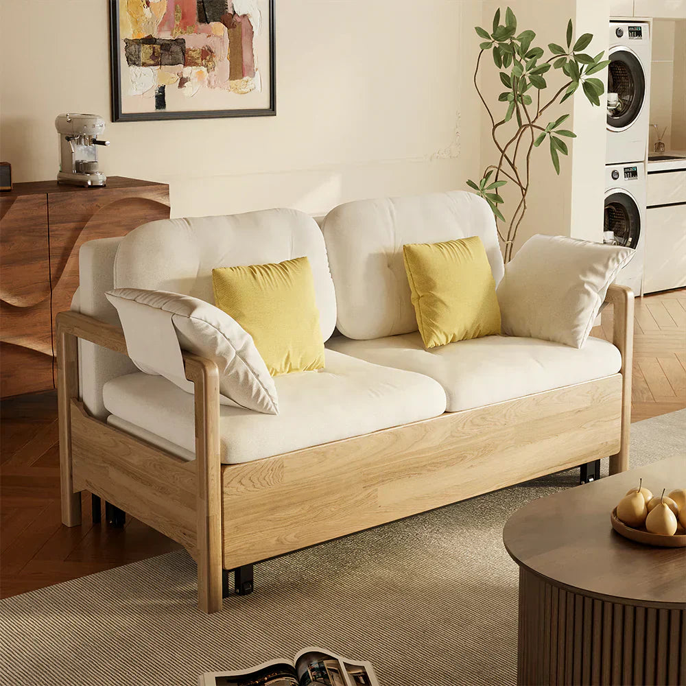 Solid wood framed sofa bed with light fabric cushions and yellow accent pillows, shown in a warm, lived-in living room setting, highlighting sturdy construction and everyday comfort.