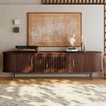 Load image into Gallery viewer, Wooden entertainment console with decorative items in a living room setting
